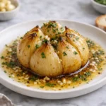 roasted onion boil with melted butter garlic herbs in white plate