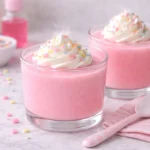 pink tubby custard dessert served in glass cups with whipped cream and sprinkles