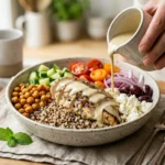 high protein mediterranean bowl recipe with chicken quinoa chickpeas feta on white marble