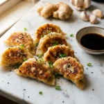 Crispy cabbage dumplings with golden-brown pan-fried bottoms on white marble