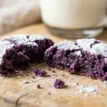 Ube crinkle cookie broken in half showing a soft fudgy purple center
