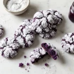 Ube crinkle cookies with bright purple centers and snowy cracked powdered sugar tops